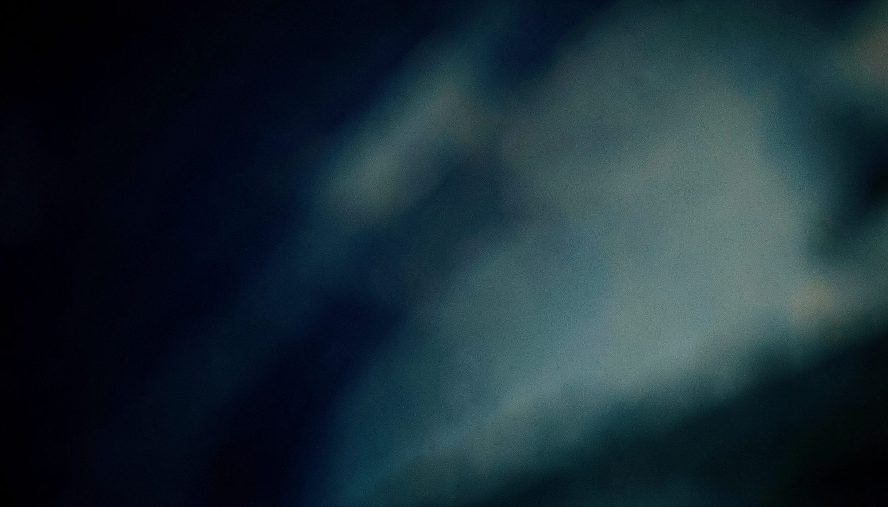 Soft-focus abstract background in deep navy and muted teal tones, with subtle organic curves suggesting a calm, professional atmosphere.